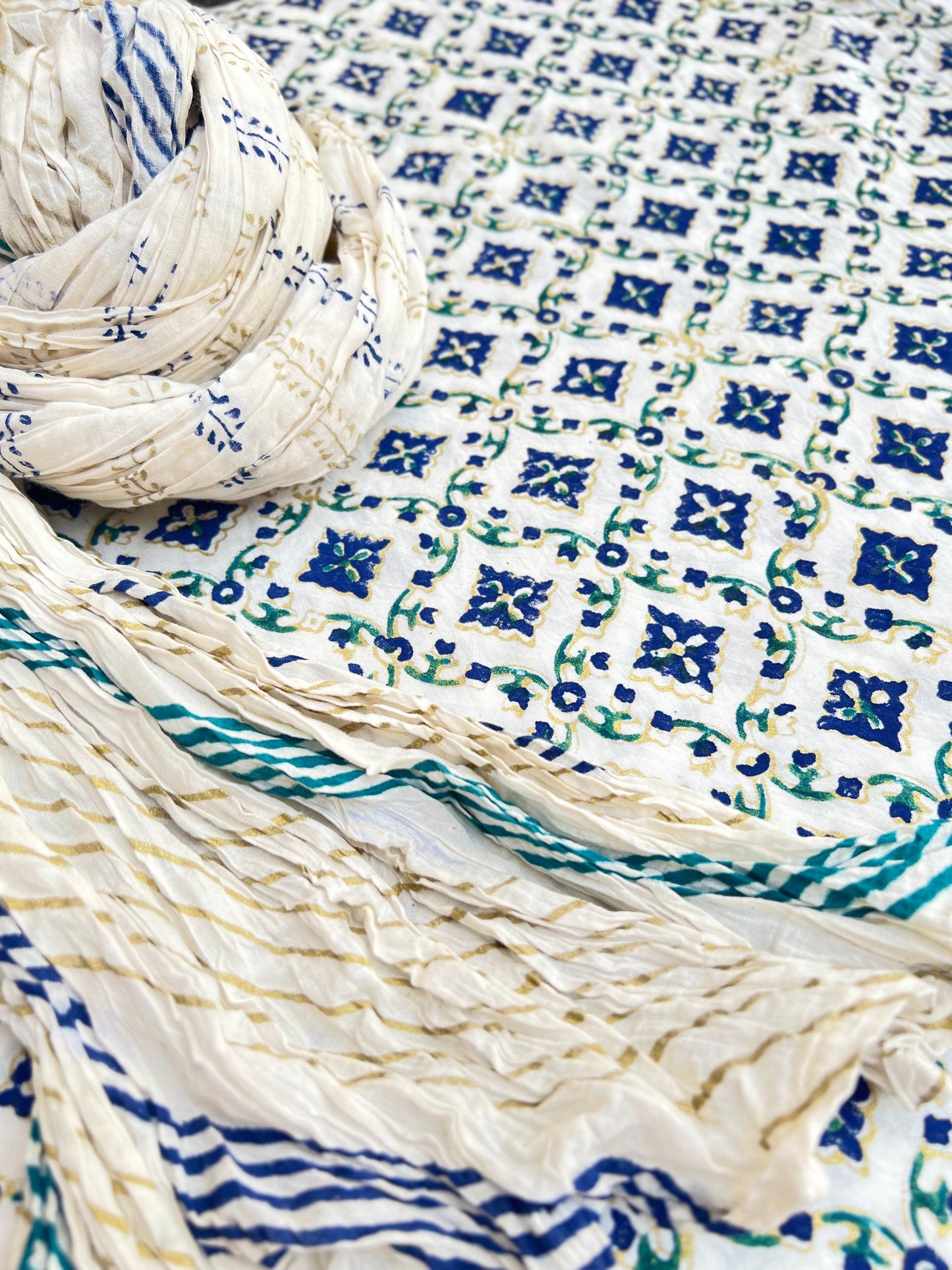 Gold Ferozi and Blue printed Gul-e-Nargis flower design on kora white fabric.